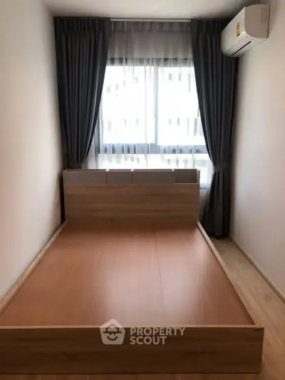 Modern minimalist bedroom with wooden bed frame and large window.
