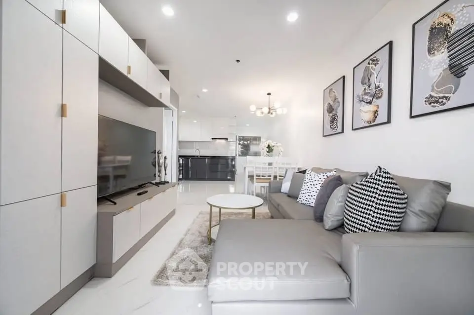 Modern living room with sleek furniture and open kitchen layout in a stylish apartment.