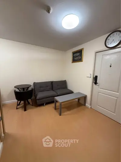 Cozy living room with modern furniture and wall clock, perfect for relaxation.