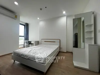 Modern minimalist bedroom with large window and sleek furniture