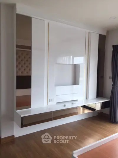 Modern living room with sleek built-in entertainment unit and wooden flooring
