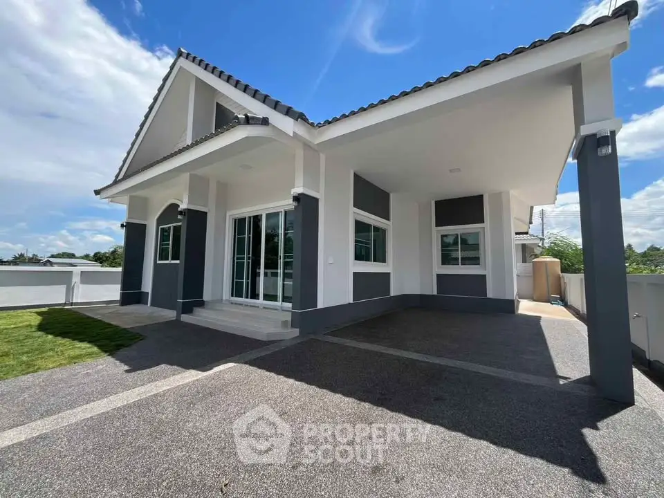 Modern single-story house with spacious driveway and elegant exterior design.