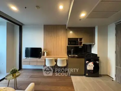 Modern open-layout kitchen with sleek appliances and cozy dining area in a stylish apartment.