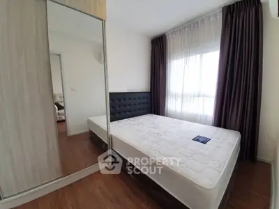 Spacious bedroom with large window and mirrored wardrobe, perfect for natural light lovers.