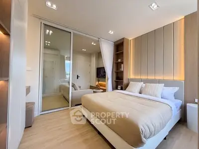Modern bedroom with elegant lighting and sliding glass doors in a stylish apartment.