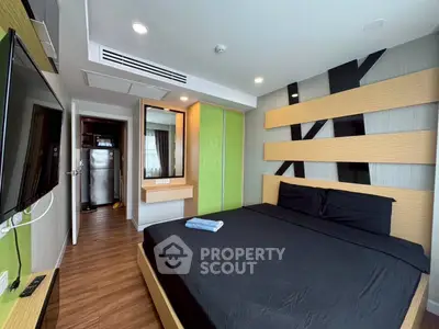 Modern bedroom with sleek design, featuring a large bed, wall-mounted TV, and stylish decor.