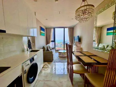 Modern open-plan living room with kitchen, featuring elegant decor and stunning city view.