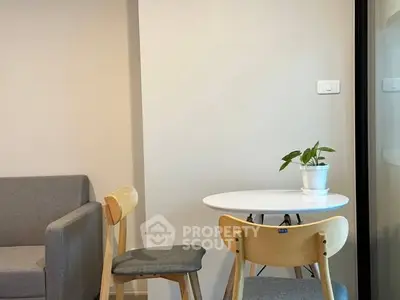 Cozy living room with modern furniture and a small dining area.