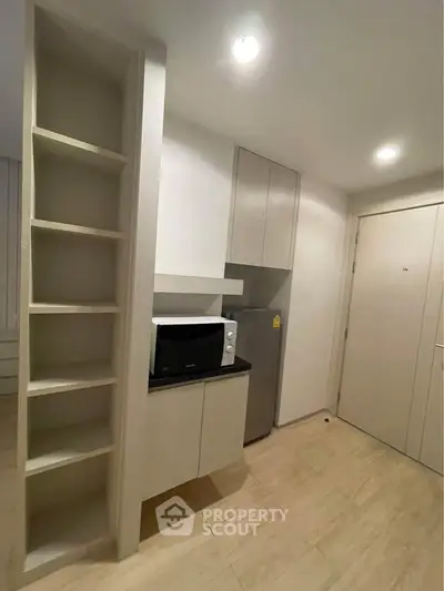 Modern compact kitchen with sleek cabinetry and built-in appliances