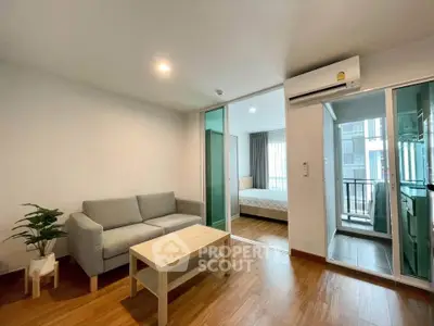 Modern apartment interior with cozy living room and bedroom, featuring wooden flooring and natural light.