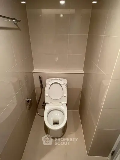 Modern bathroom with sleek tile design and toilet, showcasing minimalist style.