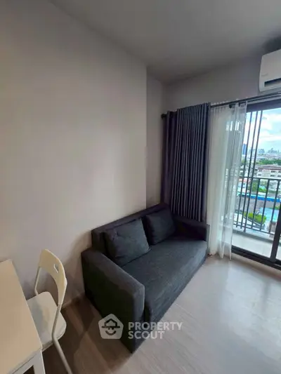 Modern living room with sleek sofa and city view balcony, perfect for urban living.