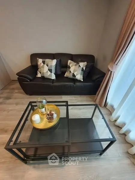 Cozy living room with modern sofa and glass coffee table, perfect for relaxation.