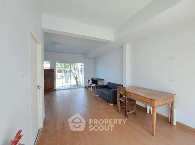 Spacious living room with wooden flooring and natural light