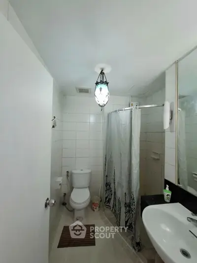 Cozy bathroom with modern fixtures and shower curtain in a real estate property.