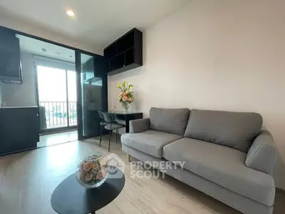 Modern living room with gray sofa and balcony view in stylish apartment