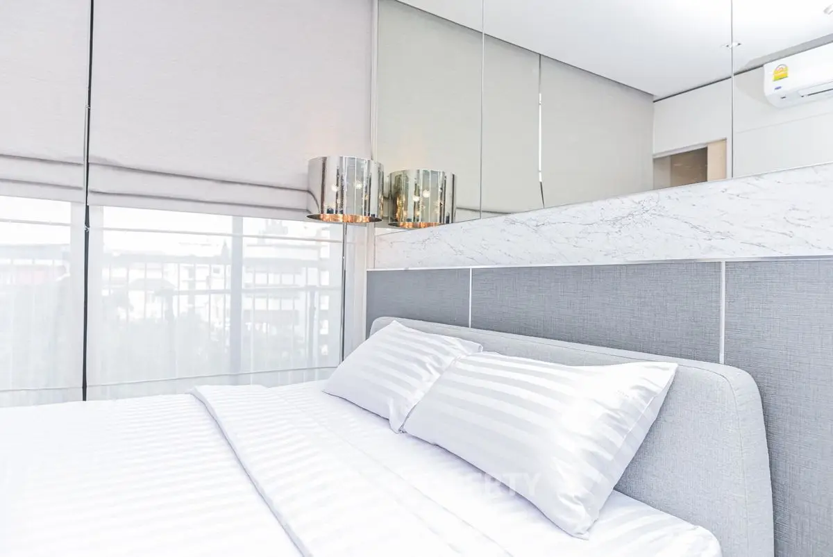 Modern bedroom with stylish decor and large windows for natural light.