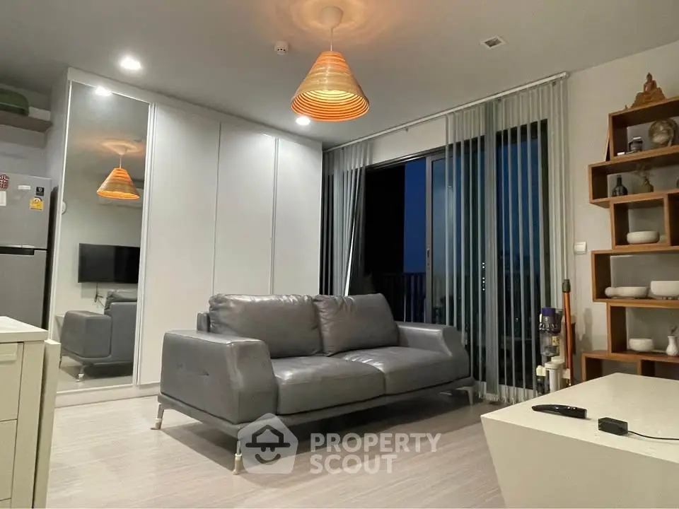 Modern living room with sleek gray sofa and balcony access