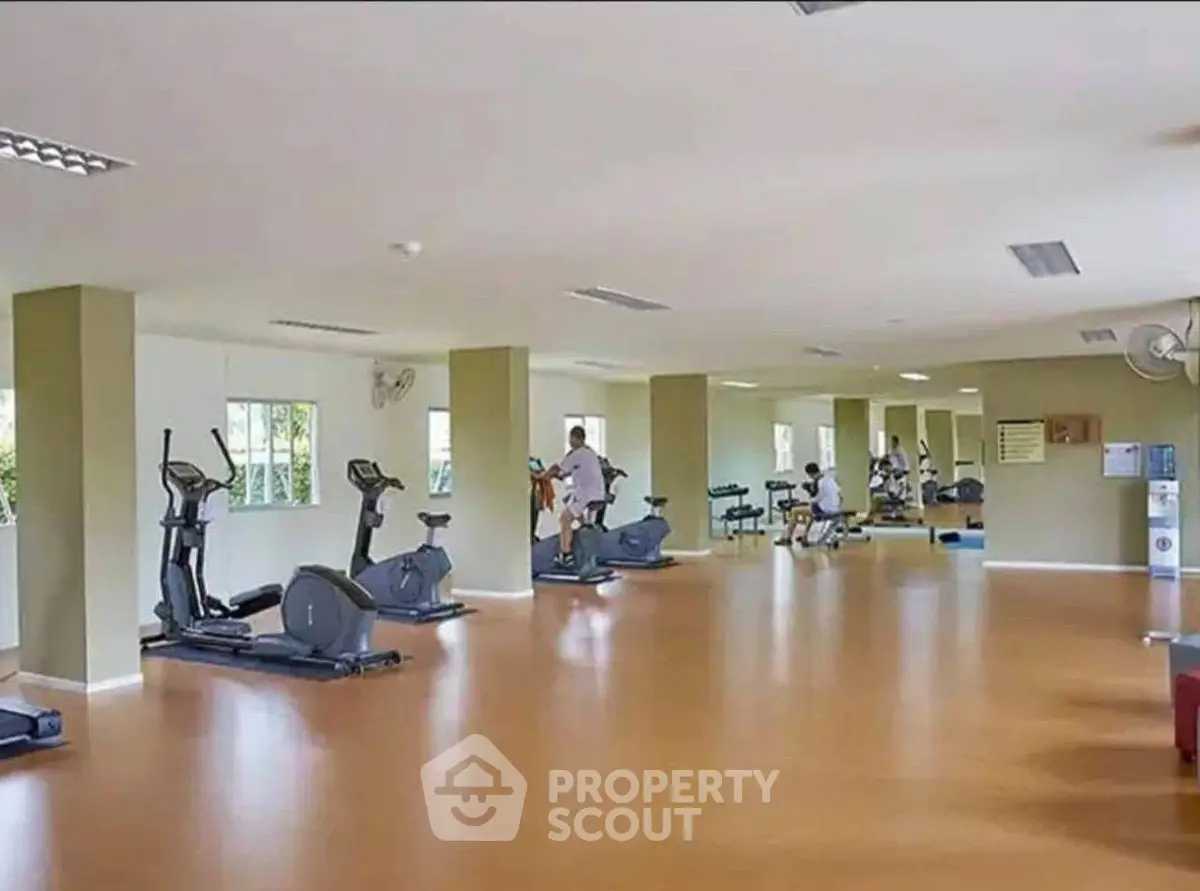 Spacious gym with modern exercise equipment in a residential building.