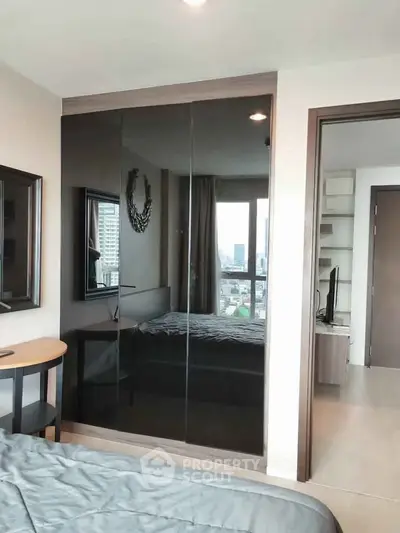 Modern bedroom with sleek mirrored wardrobe and city view window