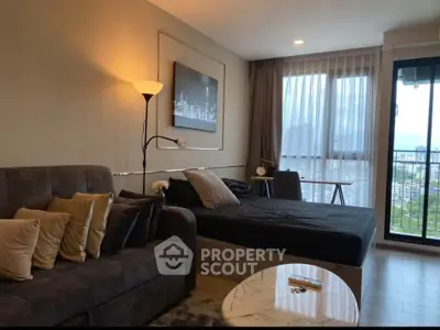 Modern living room with cozy sofa, stylish decor, and city view from large window.