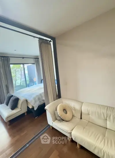 Spacious bedroom with cozy seating area and large window view