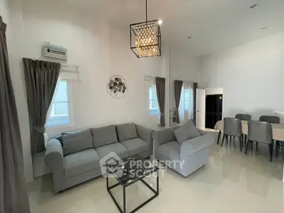 Spacious modern living room with elegant gray sofas and chic lighting, perfect for relaxation and entertaining.