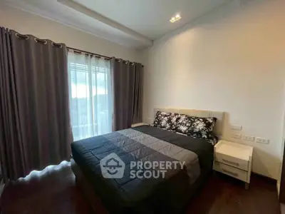 Cozy bedroom with elegant decor and natural light through large windows, perfect for relaxation.