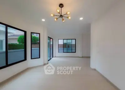 Spacious modern living room with large windows and stylish lighting in a contemporary home.
