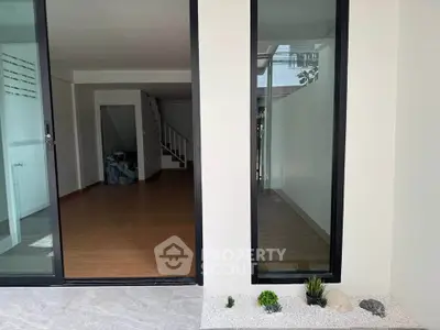 Modern open-plan living space with large windows and wooden flooring, perfect for natural light and contemporary living.