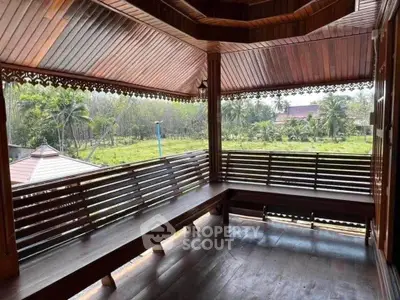 Charming wooden balcony with scenic views of lush greenery and traditional architecture.