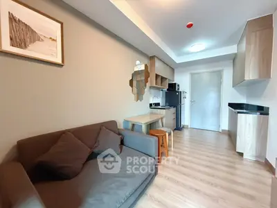 Modern living room with sleek furniture and open kitchen layout.