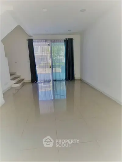 Spacious empty living room with large windows and glossy tiled floors, perfect for customization.