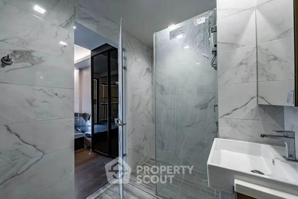 Modern bathroom with sleek marble tiles and glass shower enclosure