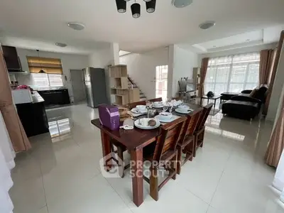 Spacious open-plan living and dining area with modern kitchen and natural light.