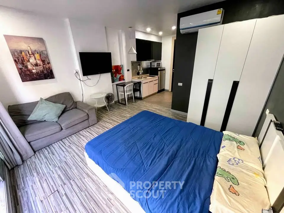 Modern studio apartment with cozy living area and compact kitchen, featuring stylish decor and ample natural light.