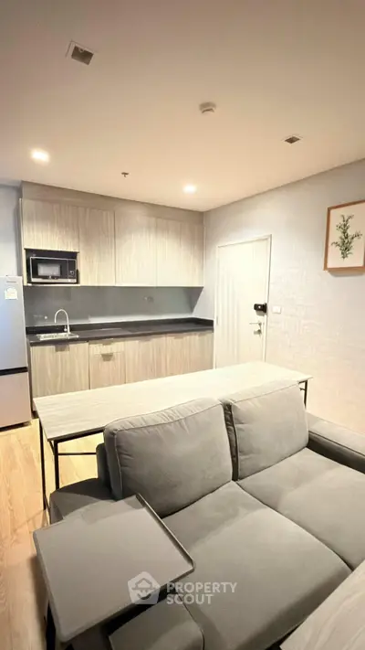 Modern open-layout kitchen with sleek cabinetry and cozy living area