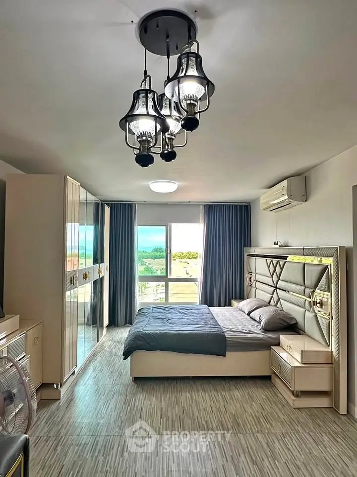 Spacious bedroom with modern decor and large window offering scenic view.