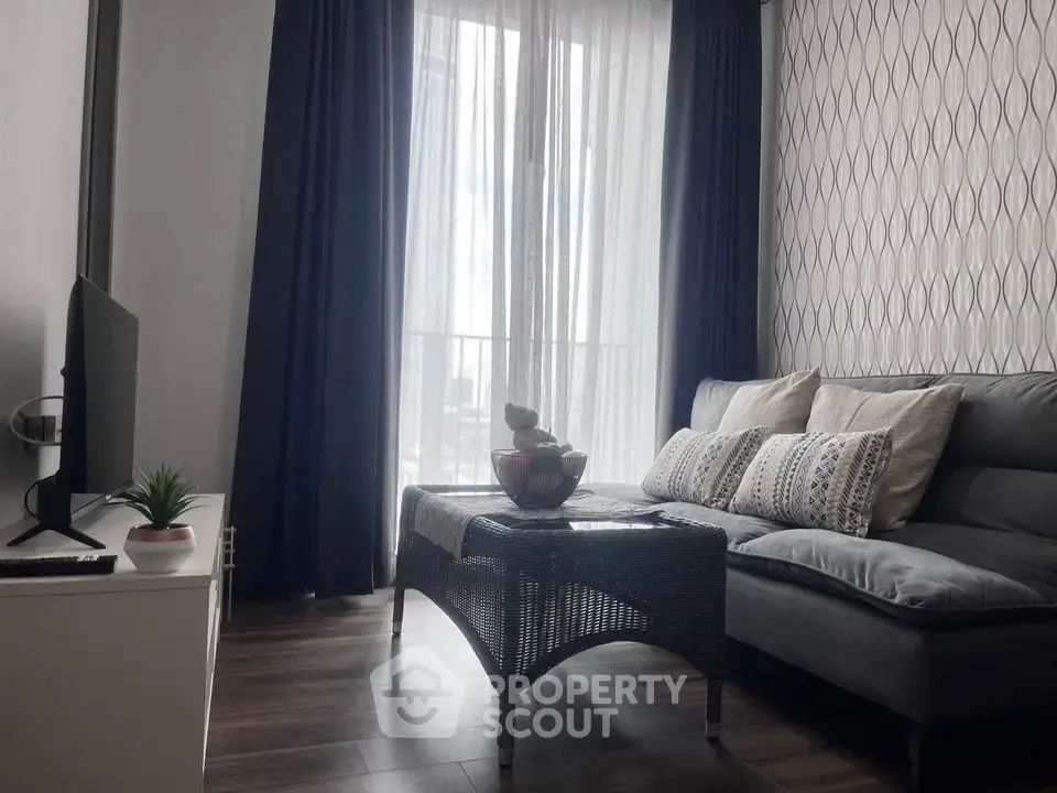 Cozy living room with modern decor and natural light through large window.