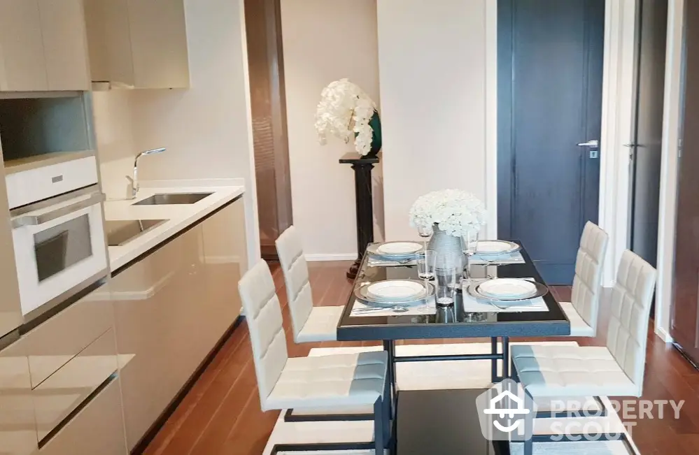 Modern kitchen with sleek cabinetry and elegant dining setup in luxury apartment.