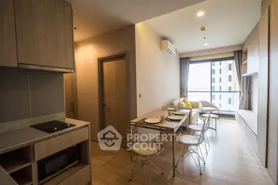 Modern apartment interior with open kitchen and dining area, featuring stylish furniture and large window view.