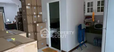 Spacious storage area with stacked boxes and a small kitchenette corner, ideal for organizing and utility.