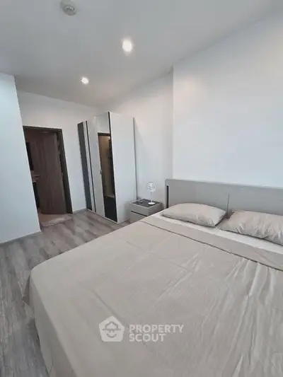 Modern bedroom with sleek design, featuring a comfortable bed and spacious wardrobe, perfect for urban living.