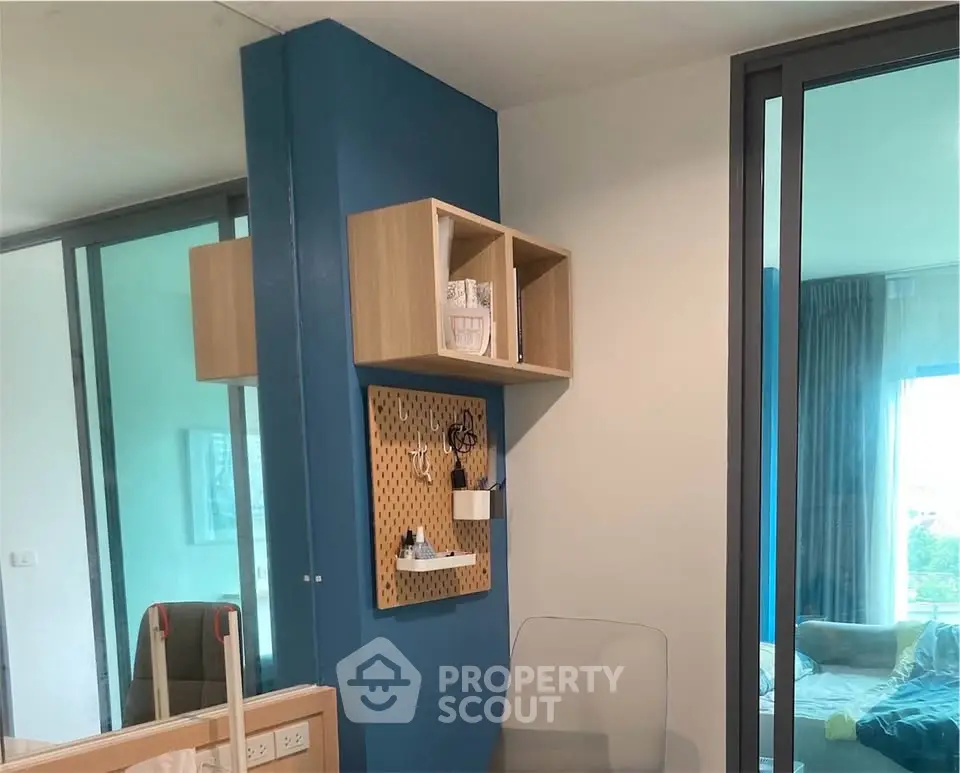 Modern interior with stylish shelving and glass partition in a cozy living space.