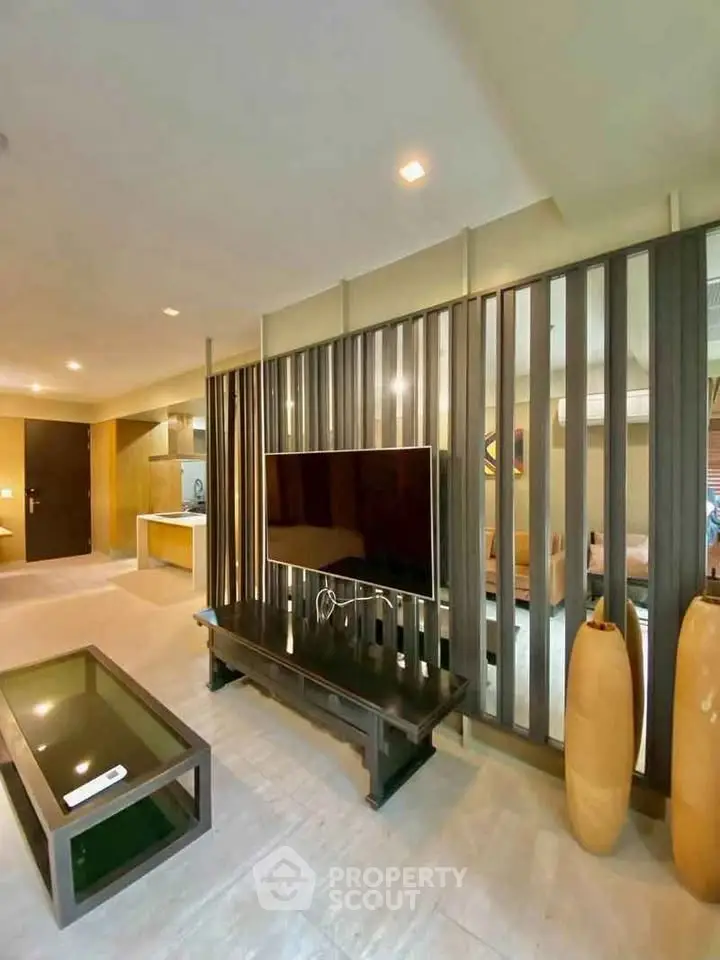 Modern living room with stylish decor and open layout, featuring a sleek TV setup and elegant furnishings.