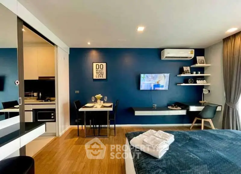 Modern studio apartment with stylish decor, open kitchen, and cozy dining area.