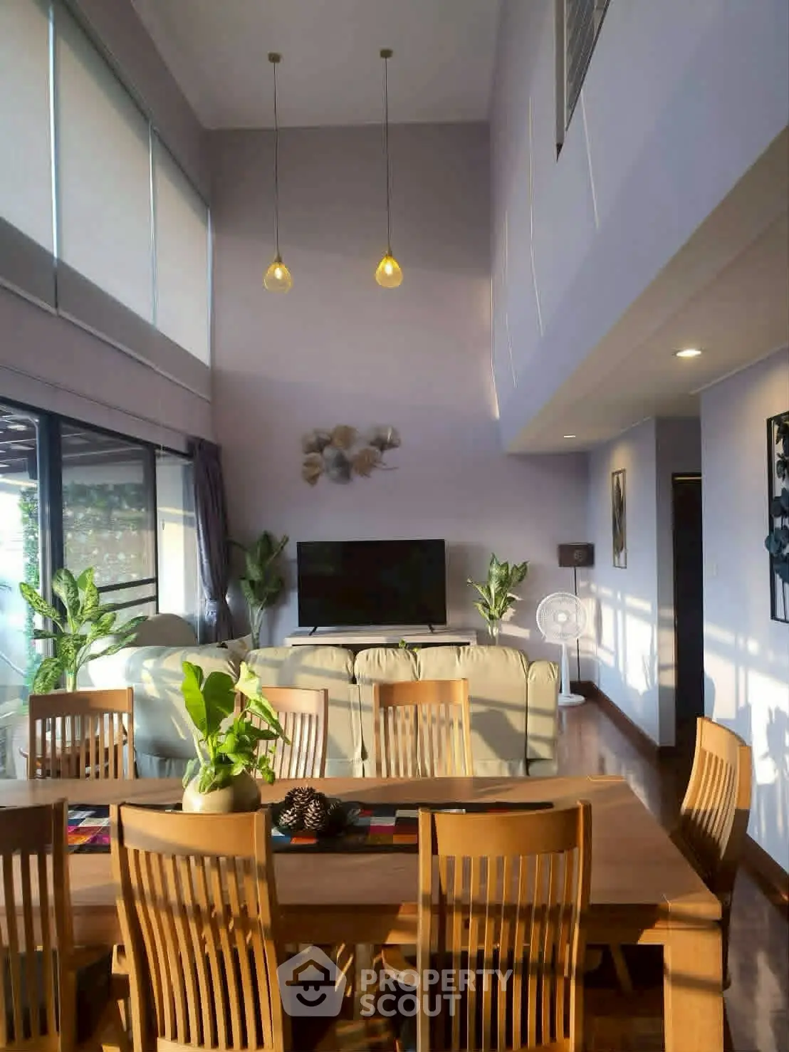 Spacious living room with high ceilings, modern decor, and abundant natural light.