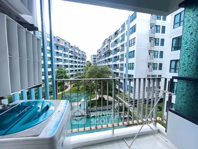 Modern apartment balcony with washing machine and scenic view of residential complex.