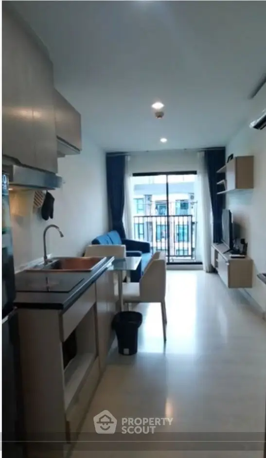 Modern open-plan living room with kitchen and balcony view