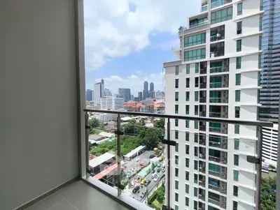 Stunning city view from modern apartment balcony with glass railing.